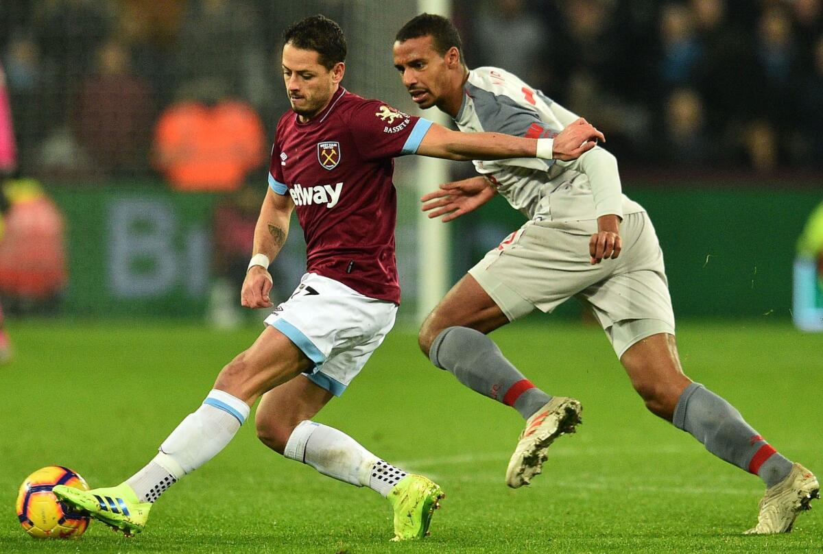 West Ham United's Mexican striker Javier Hernandez (L) pulls away from Liverpool's German-born Cameroonian defender Joel Matip during the English Premier League football match between West Ham United and Liverpool at The London Stadium, in east London on February 4, 2019.