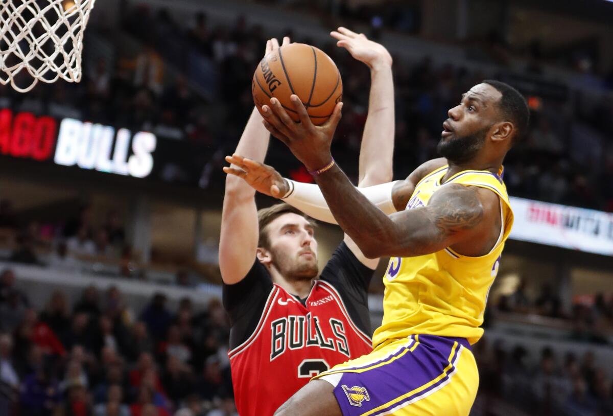 Lakers star LeBron James, right, puts up a shot in front of Chicago Bulls forward Luke Kornet.