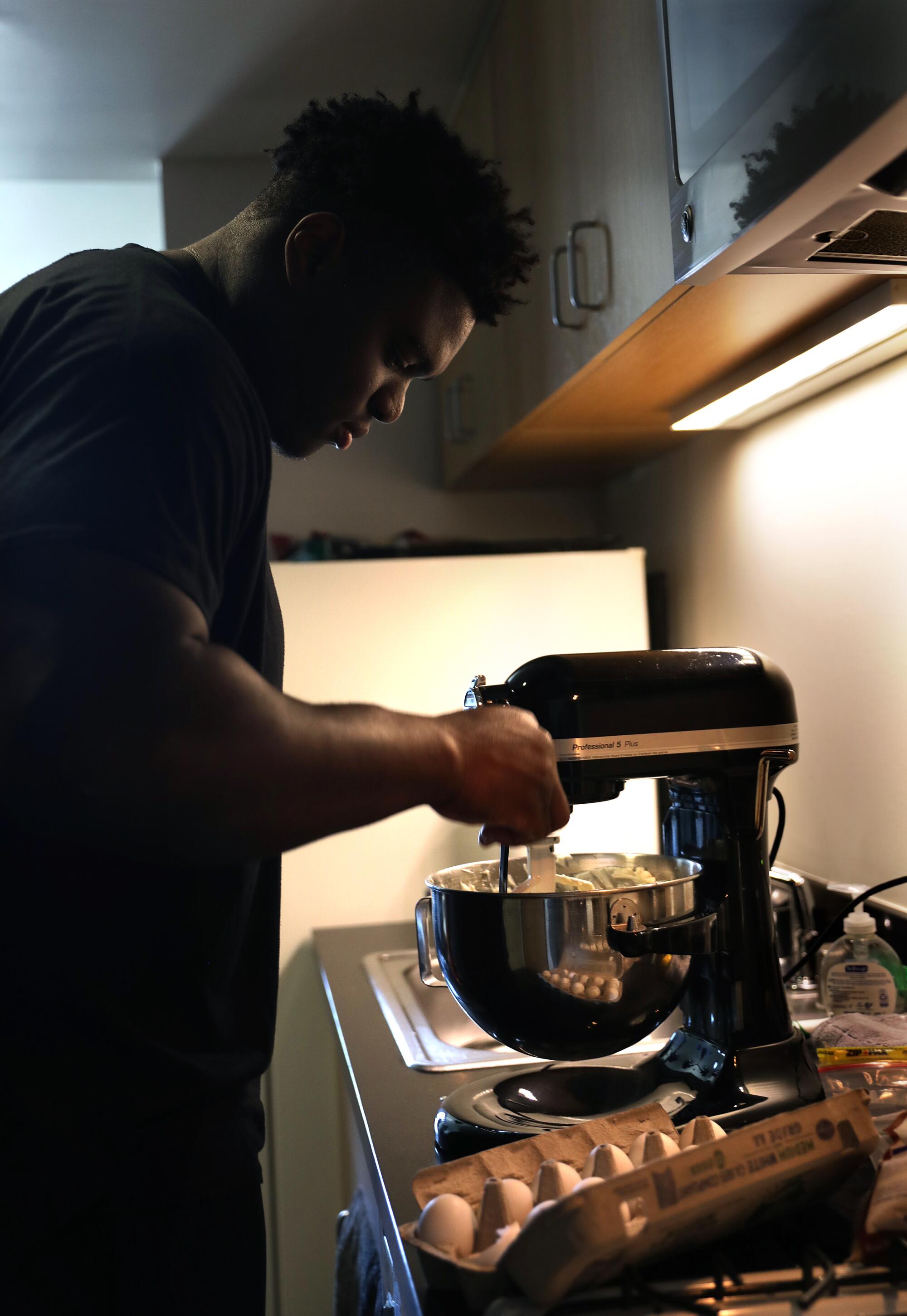 UCLA defensive lineman Otito Ogbonnia uses a stand mixer while makes a strawberry cheesecake  