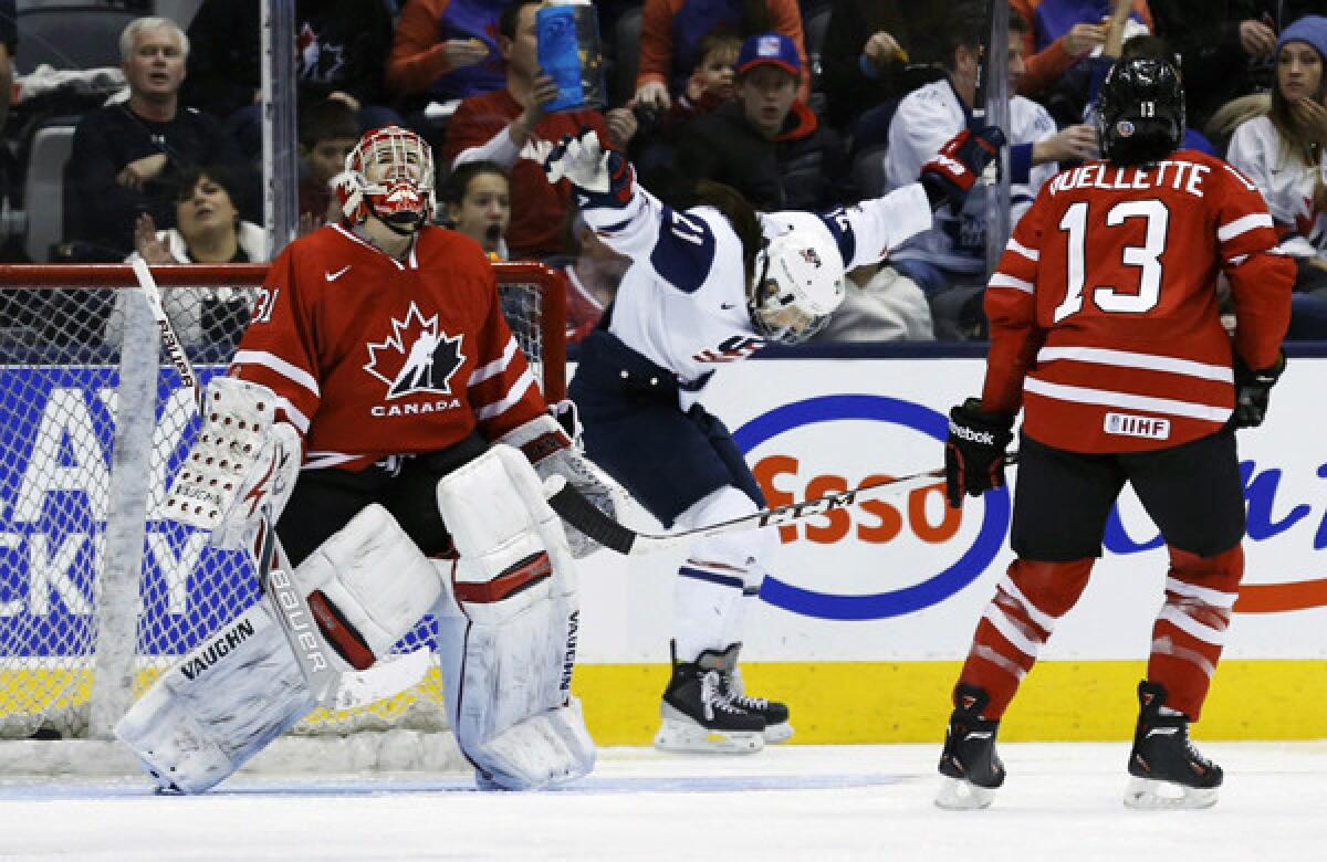 Team USA's Hilary Knight, center, celebrates after scoring past goalie Genevieve Lacasse of Canada as forward Caroline Ouellette looks on during the United States' 3-2 win Monday.