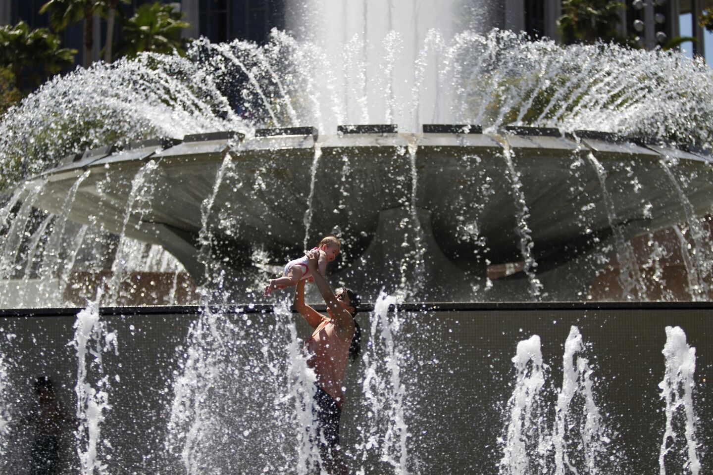 Gabby Iglesias plays with her 4-month-old daughter McKayla at Grand Park¿s Arthur J. Will Memorial Fountain.