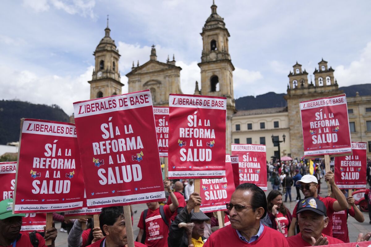 Partidarios del presidente colombiano Gustavo Petro sostienen carteles que dicen "Sí a la reforma a la salud" 