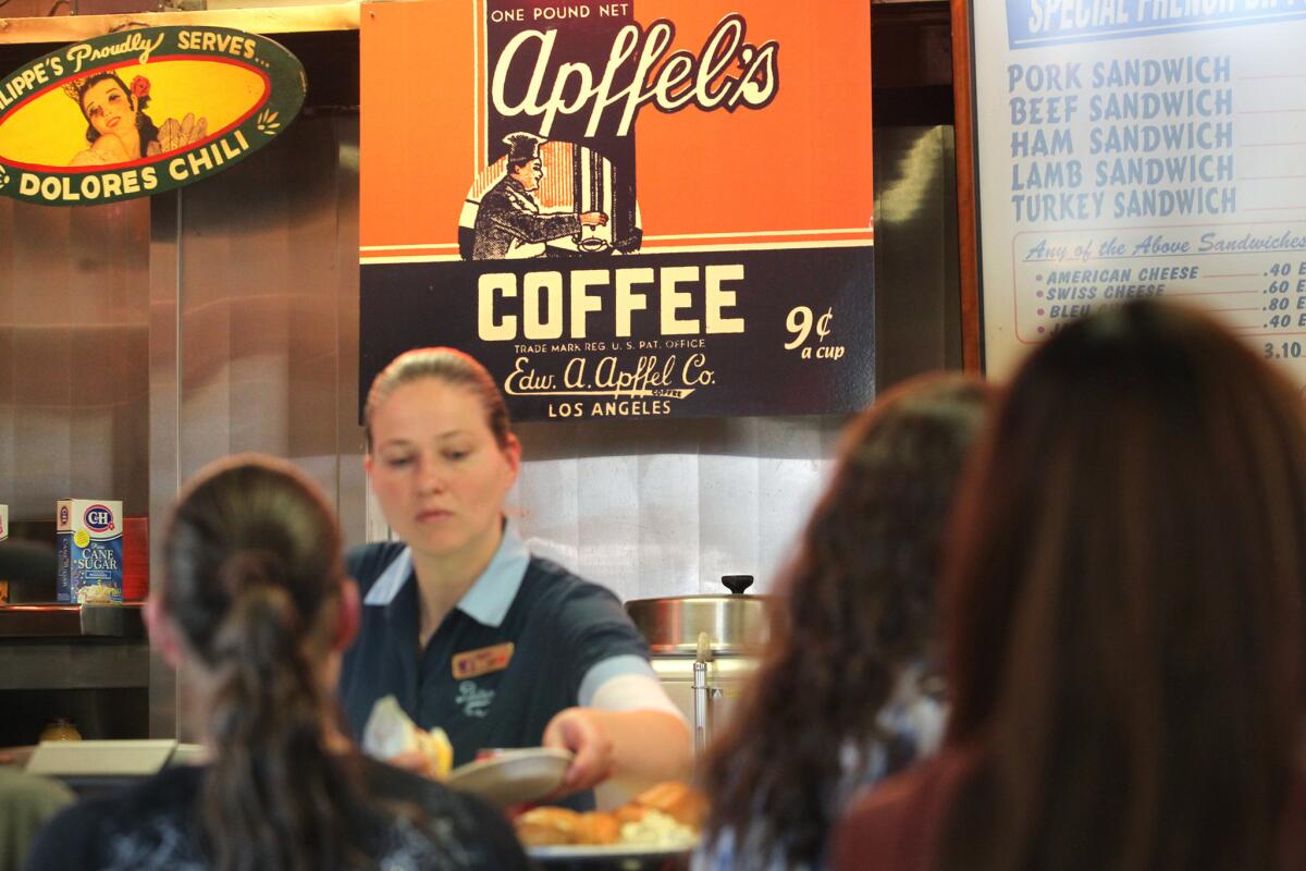 Signs advertising Dolores chili and a nine-cent cup of coffee hang at Philippe's in downtown Los Angeles.