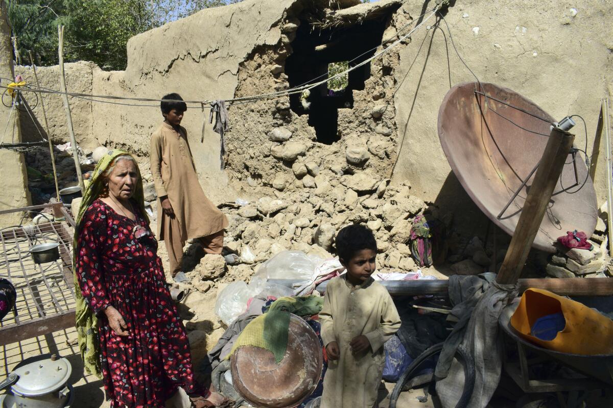 A family inside their earthquake-damaged house