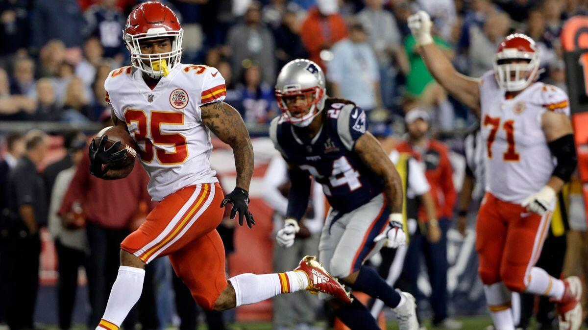 Kansas City Chiefs running back Charcandrick West (35) runs for a touchdown past New England Patriots cornerback Stephon Gilmore (24) during the second half early Friday.