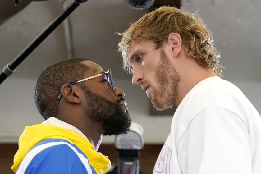 Floyd Mayweather, left, and and Logan Paul, right, face off during a press event, Thursday, June 3, 2021, in Miami Beach, Fla. Mayweather will fight Paul in an exhibition match at the Hard Rock Stadium in Miami Gardens, Fla. Sunday. (AP Photo/Lynne Sladky)