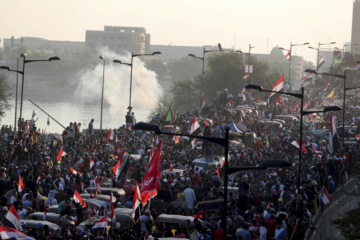 Iraqi security forces use tear gas to disperse a massive antigovernment protest in Baghdad on Friday.