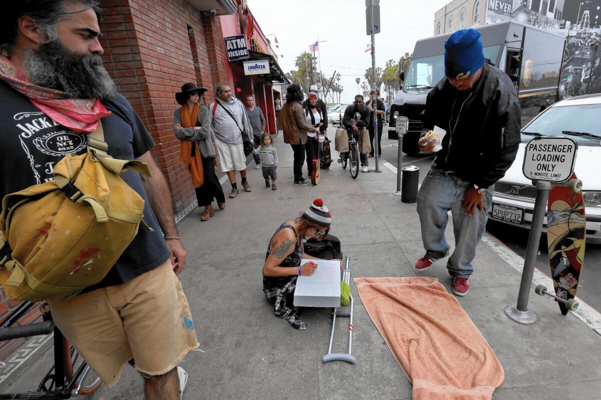 Allison Holden, 23, center, sits on the Venice sidewalk where her friend Brendon Glenn was killed in an officer-involved shooting. “He was a drinker. He has a drinking problem,” Holden told reporters. “But we all have problems.”