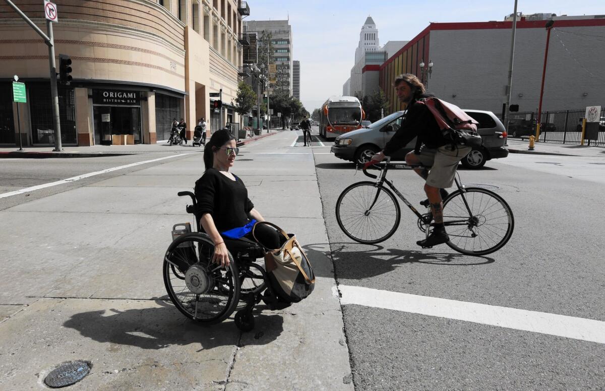 Catalina Morgan crosses Spring Street in downtown Los Angeles as she commutes on often uneven sidewalks to her office near 7th Street.