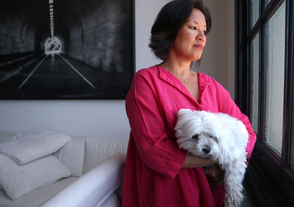 Mimi Lee holds her dog Toshi at her loft in San Francisco last month. Lee and her ex-husband are locked in a court dispute over their frozen embryos.