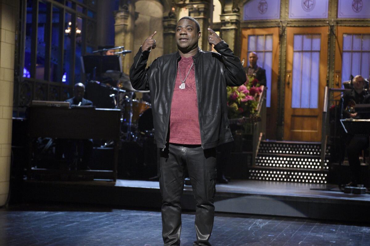 Actor and comedian Tracy Morgan returned to a familiar stage Saturday, hosting "Saturday Night Live" in his first appearance on the show since a vehicle crash that left him in a coma.