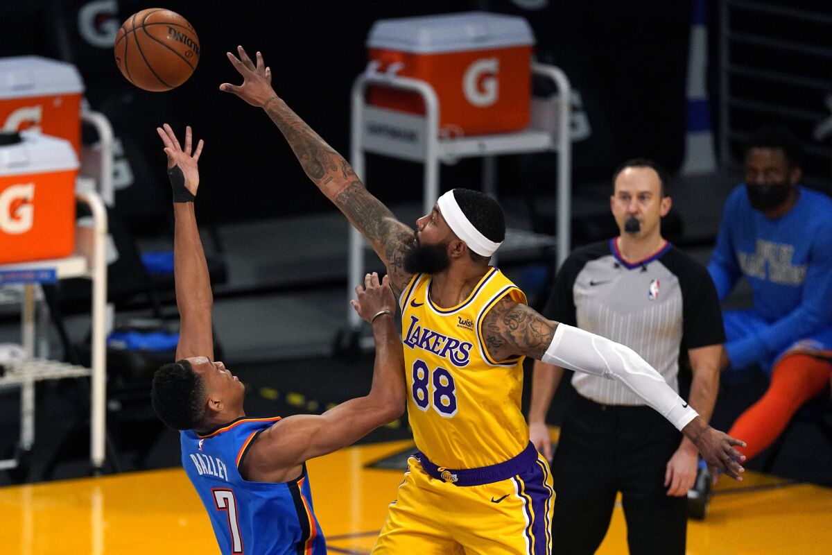 A Lakers player reaches to block a shot.