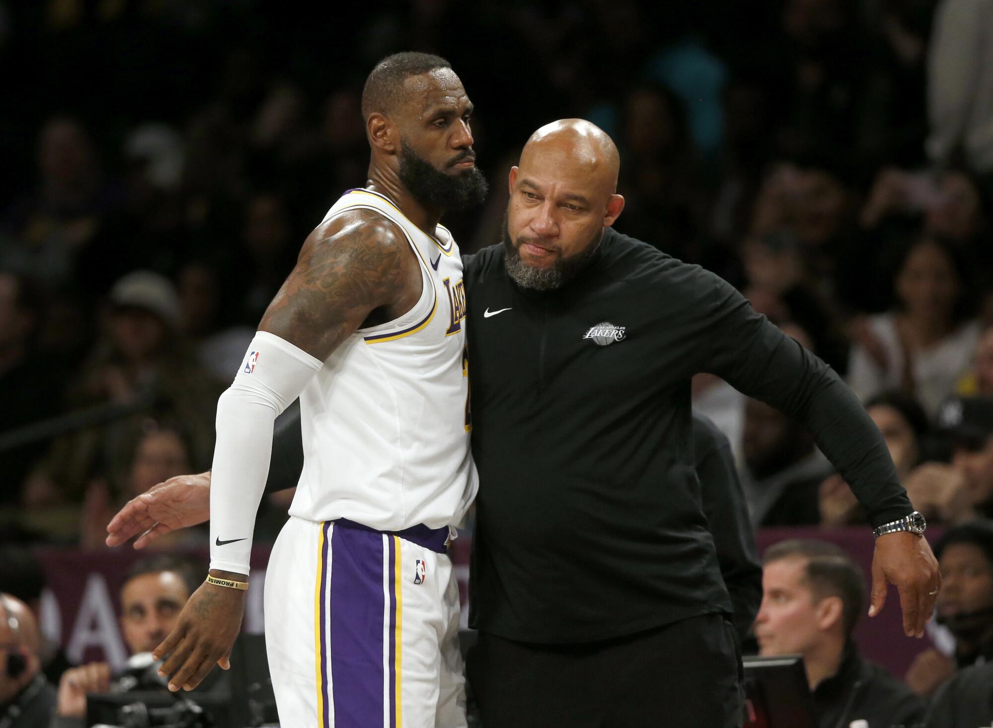 Lakers coach Darvin Ham, right, congratulates forward LeBron James during a game against the Nets last season.