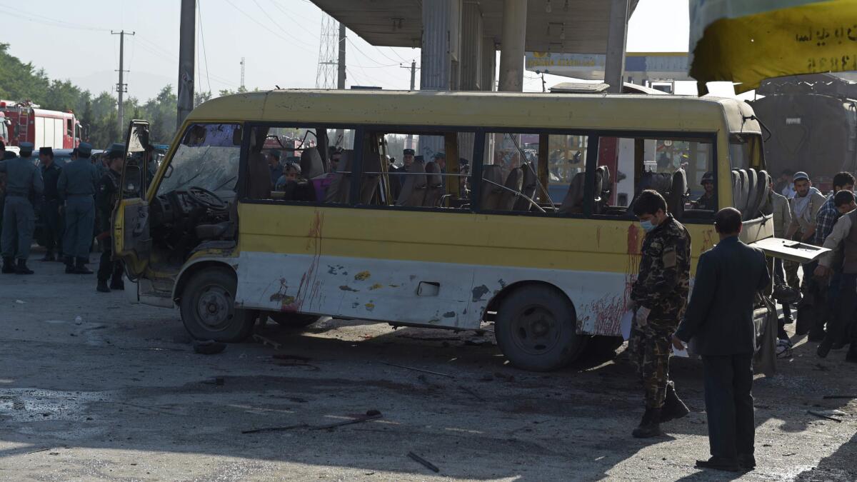 Afghan police look at the site of a suicide attack where a minibus carrying foreign security guards was targeted.