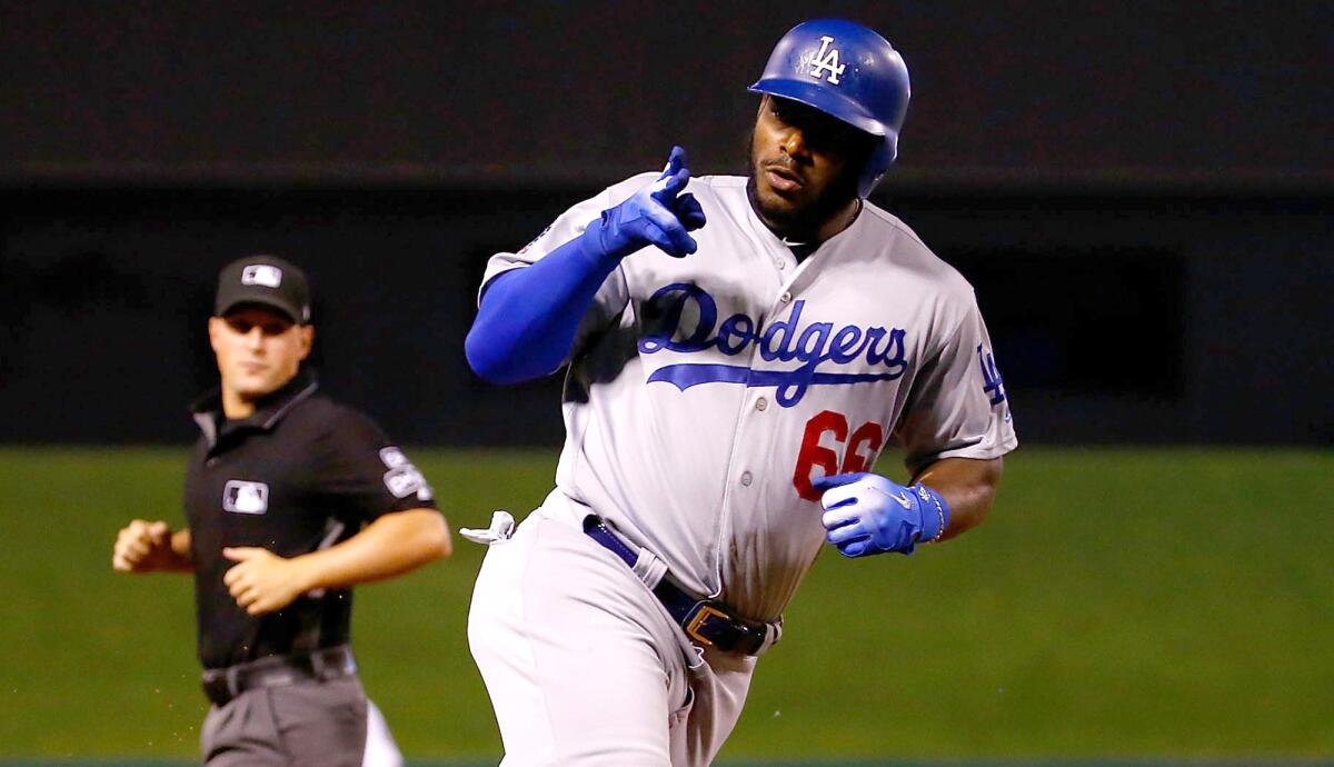 Dodgers right fielder Yasiel Puig rounds third base after hitting the first of his two home runs against the Cardinals on Friday night.