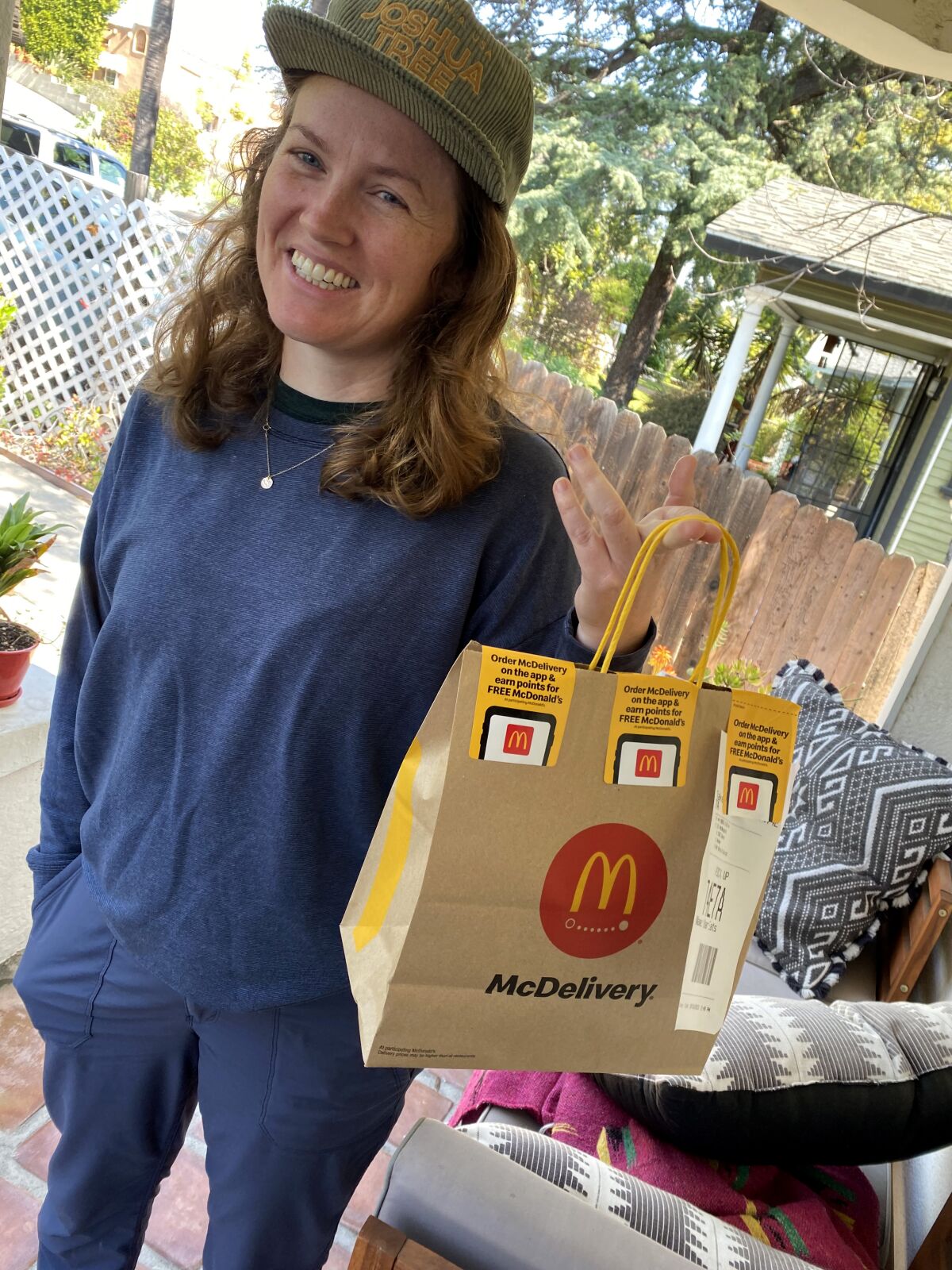 A woman holds a bag of McDonald's food