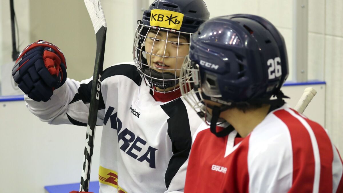 A photo from the Korean Sport and Olympic Committee shows South Korean (white jersey) and North Korean (red jersey) women ice hockey team players talking during a training session in Jincheon, South Korea, on Jan. 28.