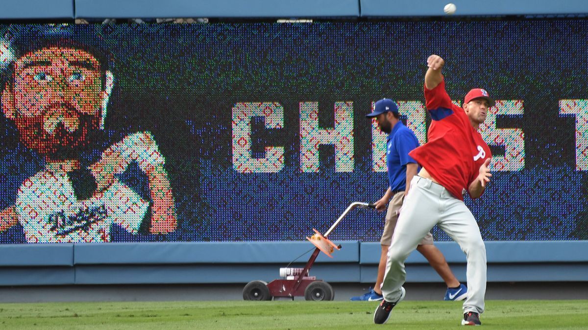 Philadelphia Phillies manager Gabe Kapler retrieves baseballs during batting practice before a game against the Dodgers at Dodger Stadium on Wednesday.