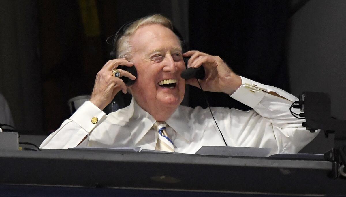 Vin Scully puts his headset on prior to a baseball game