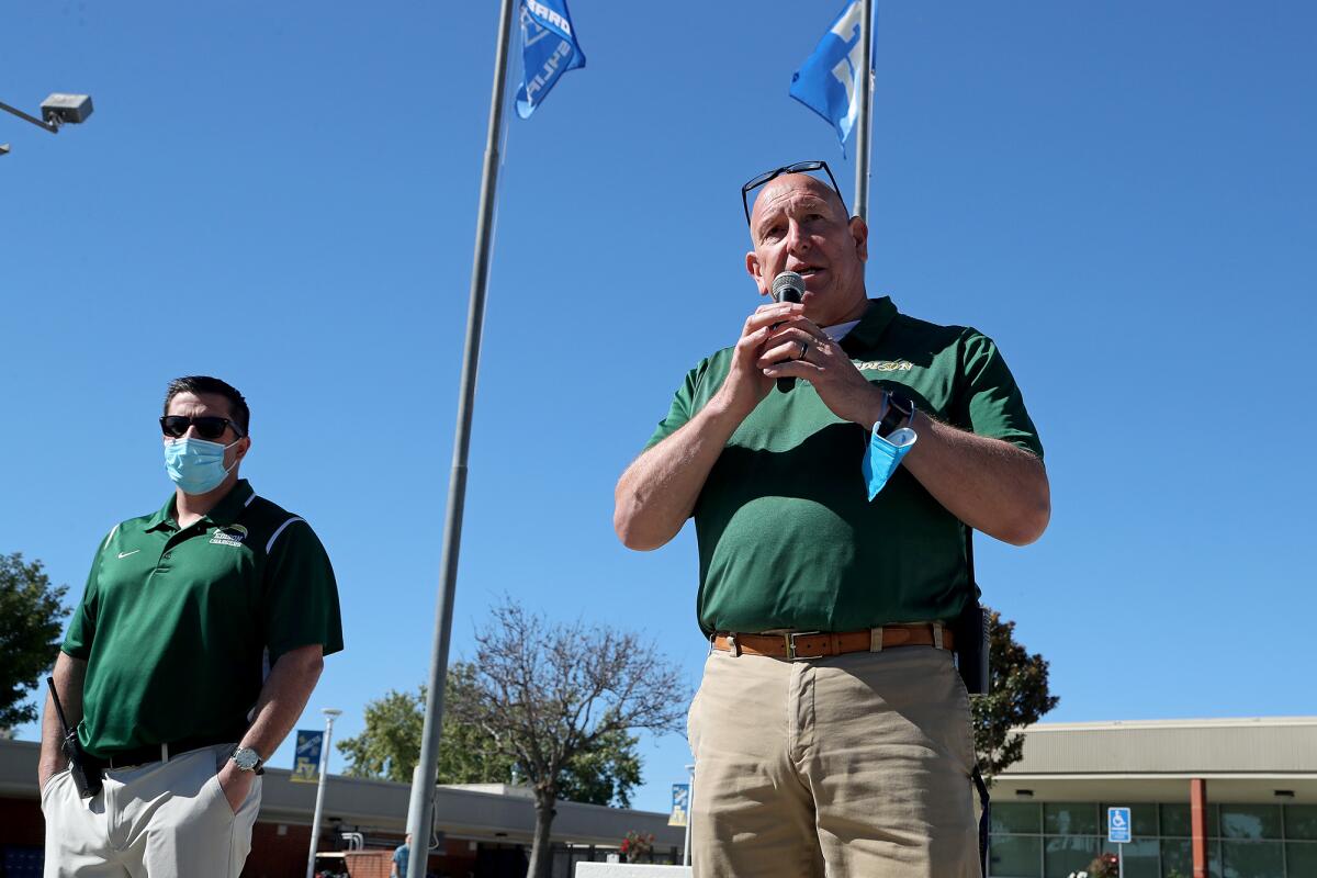 Fountain Valley High principal Paul Lopez speaks outside while assistant principal John Hurst stands nearby.