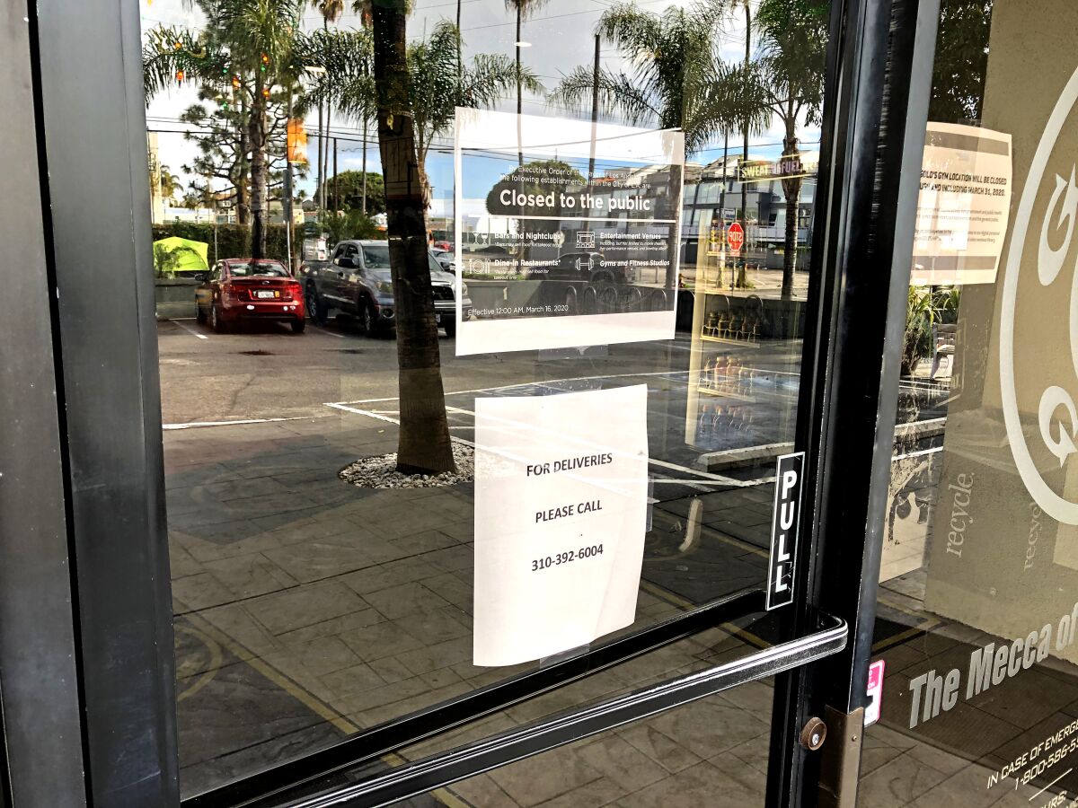 Signs taped to the door at Gold's Gym in Venice tell patrons the place is closed.