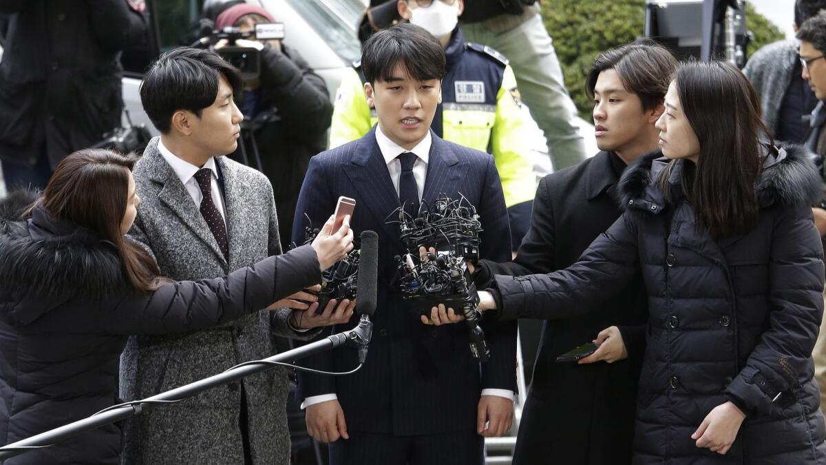 Seungri, center, a member of the popular K-pop boy band Big Bang, speaks on his arrival at the Seoul Metropolitan Police Agency in Seoul on March 14.