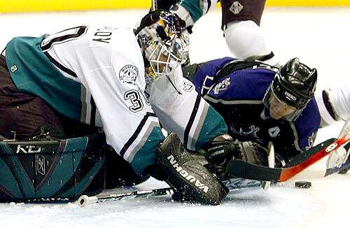 DUCK COVER: Goalie Ilya Bryzgalov of the Mighty Ducks covers a shot he blocked by the Kings' Luc Robitaille (on ice).