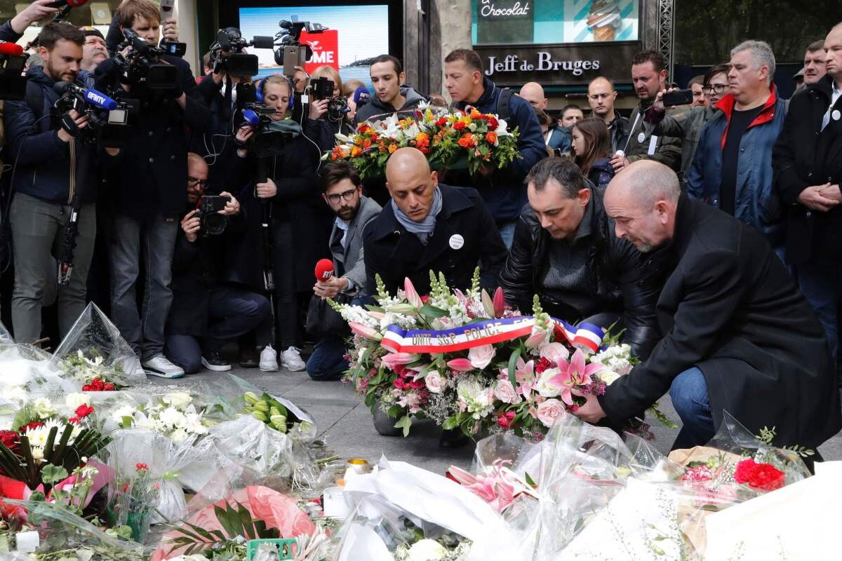People lay flowers at the site where a police officer was killed by an Islamic State jihadist on the Champs-Elysees during a demonstration of French police officers on April 26, 2017.