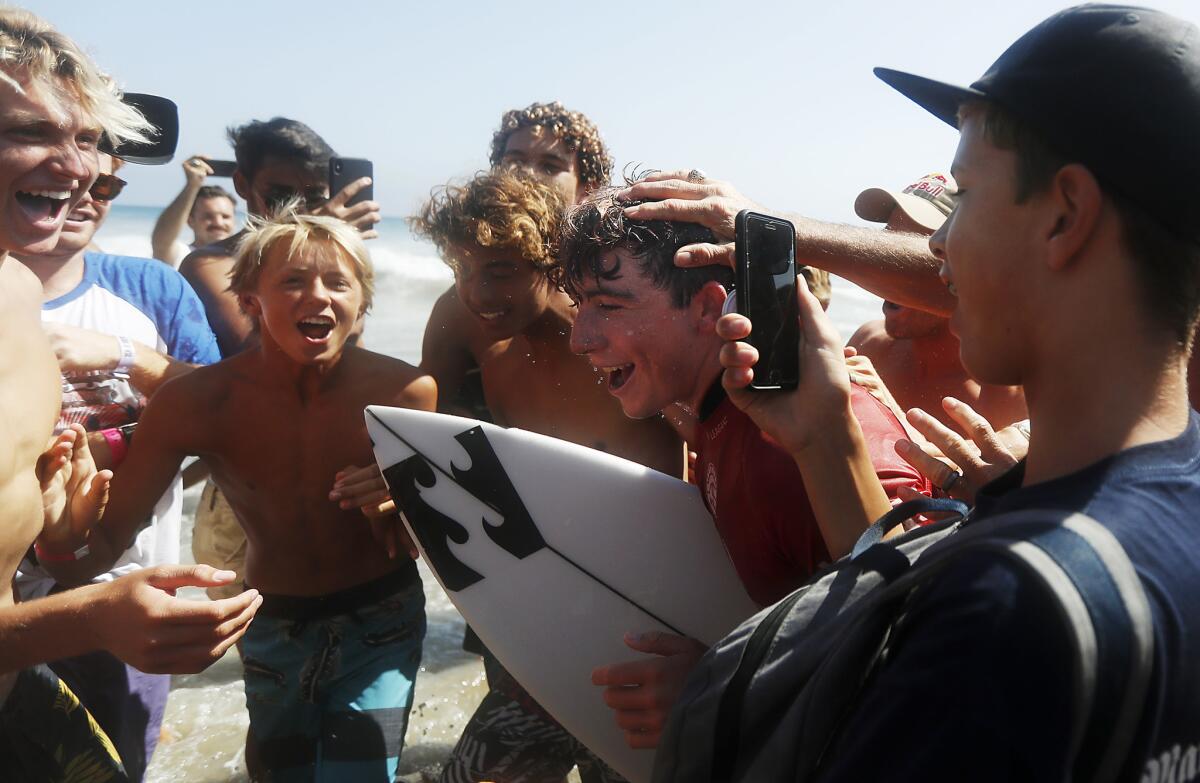 HUNTINGTON BEACH, CALIF. - AUG. 5, 2018. Fans mob Griffin Colapinto after he placed second in the finals of the 2018 Vans U.S, Open of Surfing, losing to Kanoa Iragashi, on Sunday, Aug. 5, 2018, in Huntington Beach. (Luis Sinco/Los Angeles Times)