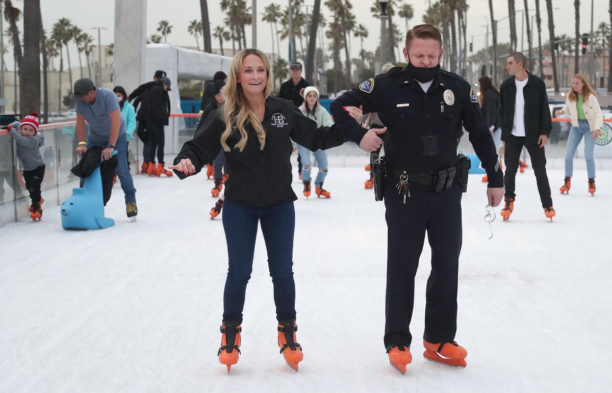 Lt. Brian Smith, right, keeps Jennifer Carey on her feet during the "Skate With HBPD" event.