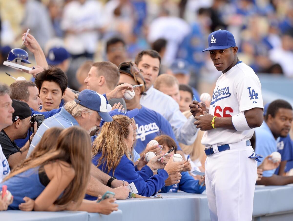 Dodgers right fielder Yasiel Puig signs autographs for fans before a game against the San Diego Padres in June.