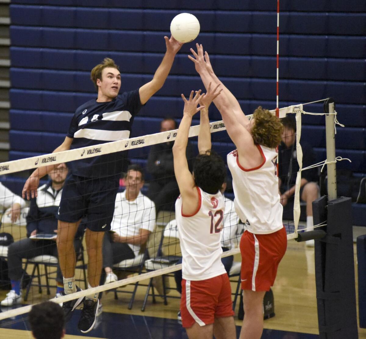 Loyola's Dillon Klein is above the net during a volleyball match.