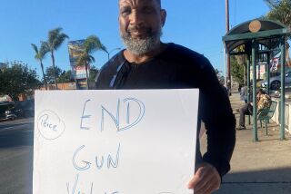 Rev. Cornelius Bowser hold up a sign against gun violence at a community protest.