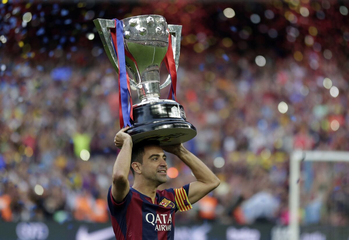 FILE - FC Barcelona's Xavi Hernandez holds up the trophy after winning the Spanish League title at the Camp Nou stadium in Barcelona, Spain on May 23, 2015. Hernández will be allowed to become Barcelona’s next coach upon the payment of his release clause from Al-Sadd, the Qatari club said Friday, Nov. 5, 2021. (AP Photo/Manu Fernandez, File)