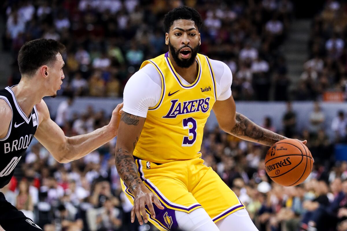 Lakers forward Anthony Davis drives against Nets forward Rodions Kurucs during a preseason game Thursday in Shenzhen, China.