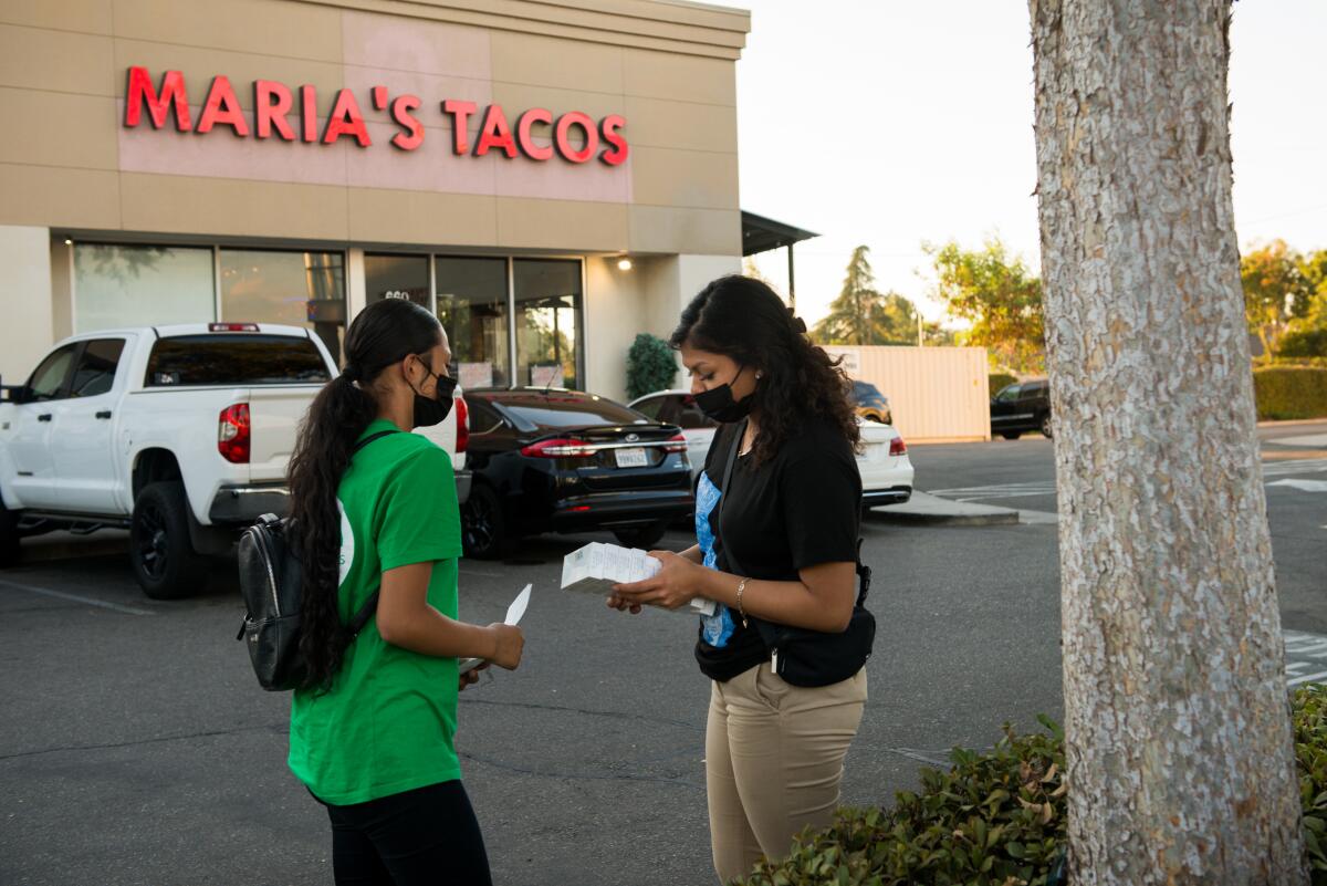 Melissa Lopez (left) and Alma Gallegos get ready to distribute c