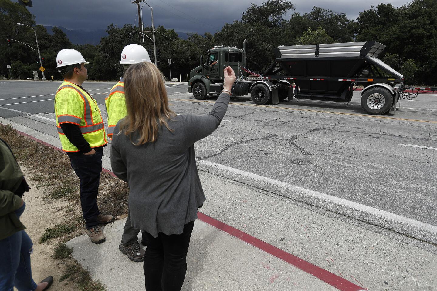 Environmentalist Liz Krider points out a debris hauler preparing to turn from Berkshire Place from Oak Grove Drive in La Canada Flintridgeon the first day of debris hauling from Devil's Gate Dam on Tuesday, May 21, 2019. The four-year project concerns local residents and leadership with the La Canada Unified School District due to the traffic of hundreds of trucks hauling debris traveling on Oak Grove Drive turning on Berkshire Place.