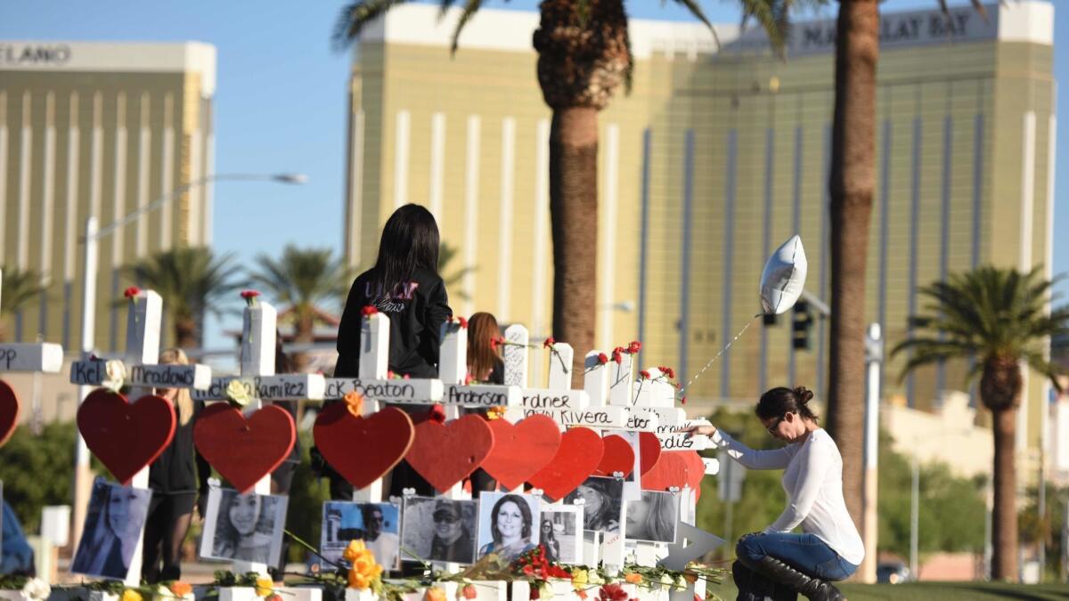 A mourner stops by 58 white crosses — one for each victim killed — in Las Vegas, five days after the Oct. 1, 2007, mass shooting.