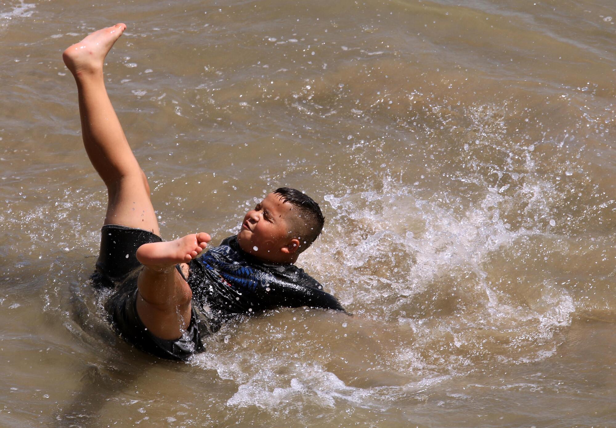 Julian Moreno, of Phoenix, Arizona, cools off in the surf on the first day of a heat wave in Santa Monica.