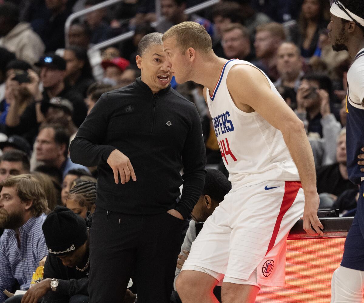 Clippers coach Tyronn Lue chats with center Mason Plumlee as he waits to check into a game.