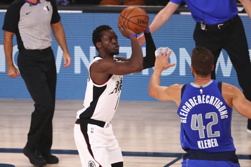 Los Angeles Clippers guard Reggie Jackson, center, shoots a three-pointer against Dallas Mavericks.