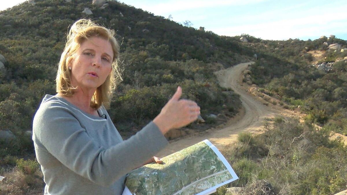 E Rita Brandin, Sr. VP ad Development Director for Newline Sierra, with a map near the high point of the property west of Interstate 15 and north of Deer Springs Road.