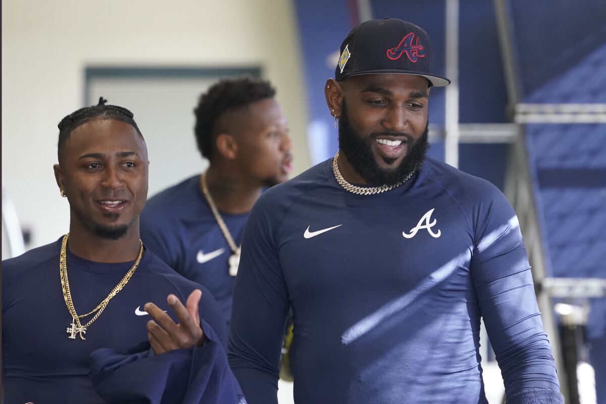 Atlanta Braves outfielder Ozuna Marcel, right, talks to teammate Ozzie Alvies in the batting cages during spring training baseball at CoolToday Park on Monday, March 14, 2022, in North Port, Fla. (AP Photo/Steve Helber)
