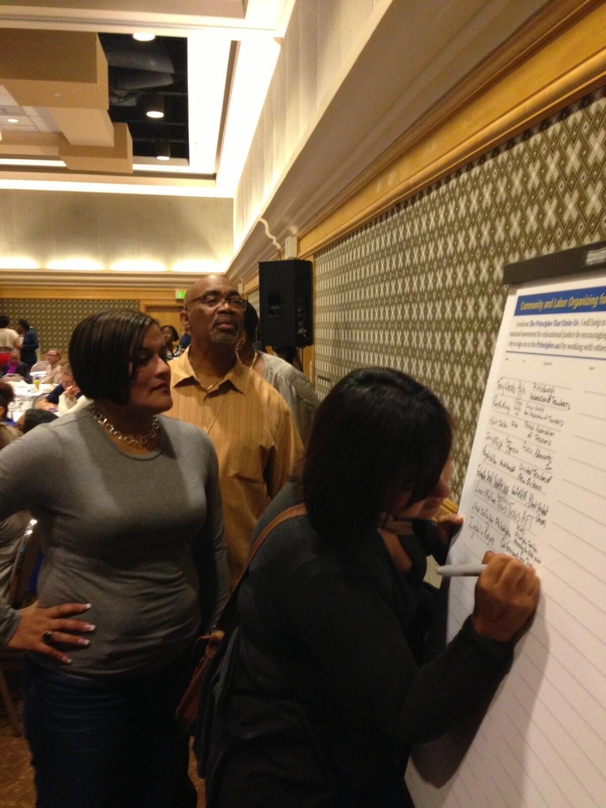 Participants line up to sign a declaration of principles at a weekend education conference in Los Angeles that took on corporate-inspired education reform.