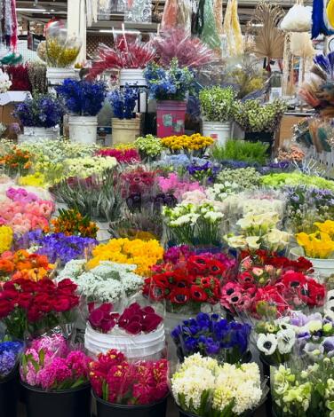 Buckets of flowers at a vendor's stall in the Los Angeles Flower Market.