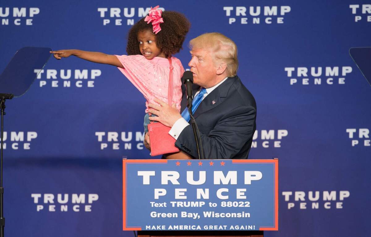 Donald Trump holds a child during a campaign rally in Green Bay, Wis., on Oct. 17.