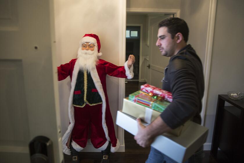 Peter Rabadi carries Christmas gifts out of his home in Porter Ranch. Peter and his wife, Danielle, will be staying with relatives until the leak from a nearby Soutthern California Gas Co. well is fixed.