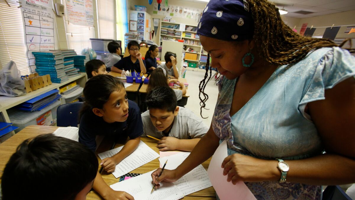 Fifth-grade teacher Teri Jackson, right, works with students at a Magnolia campus in Northridge in 2014. Three other Magnolia schools face being closed down by the L.A. Unified School District.