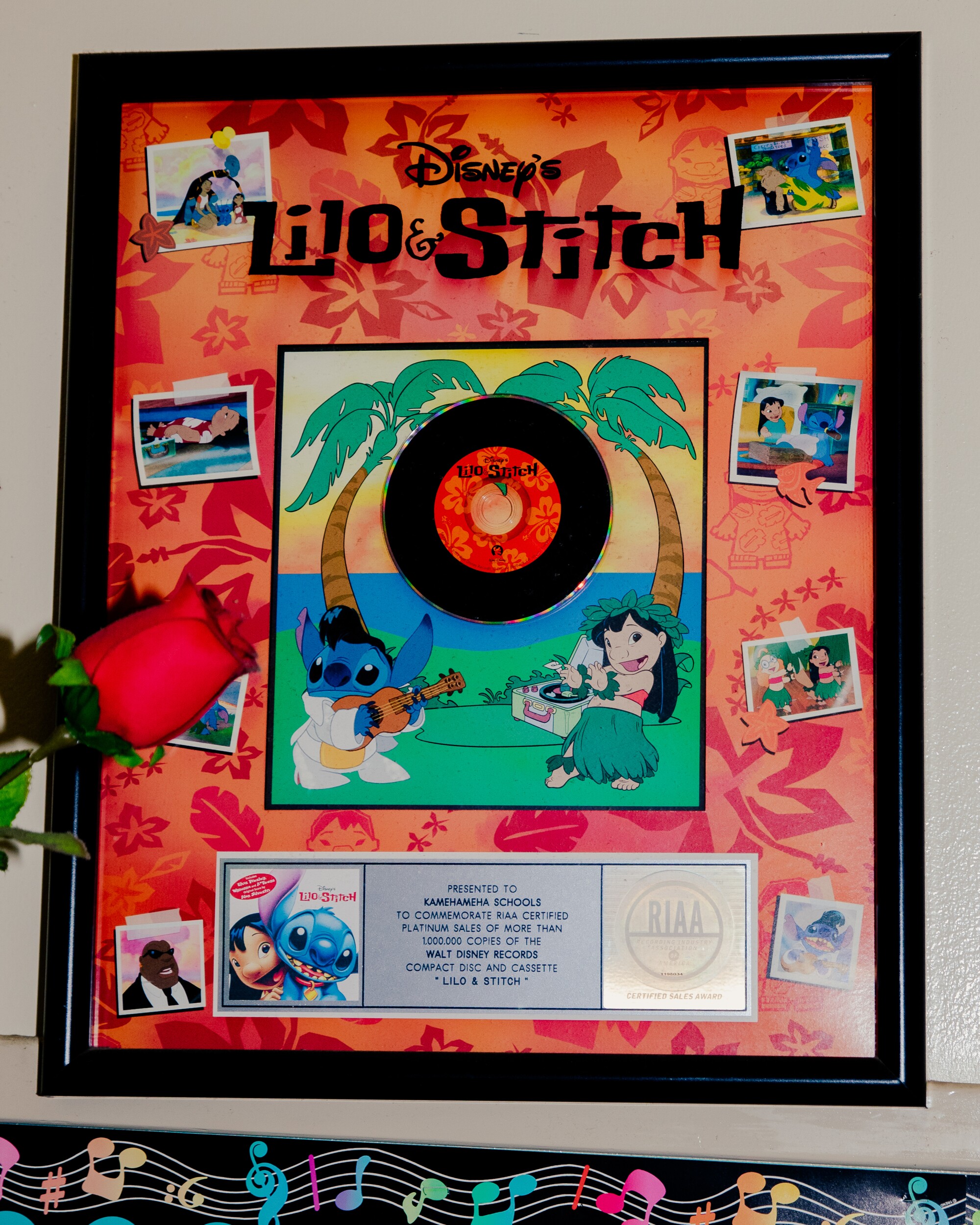 A framed plaque with a record and images from the cartoon film "Lilo & Stitch"