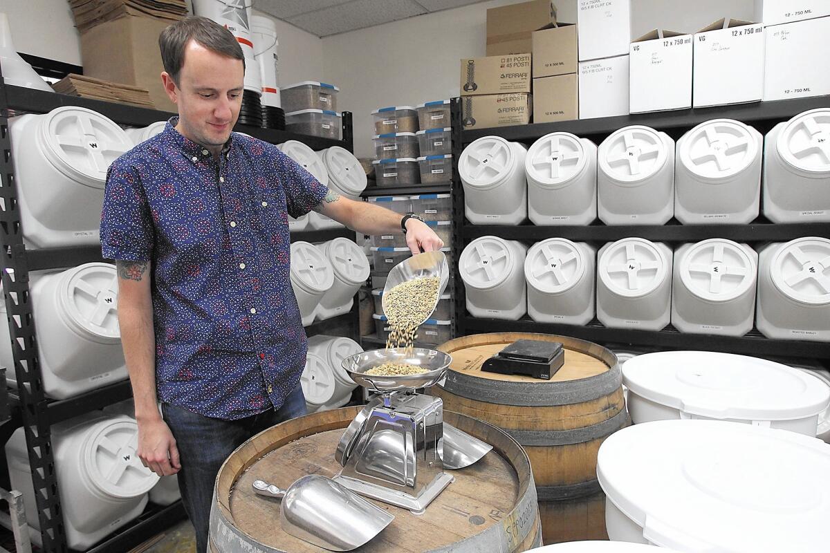 Scott Windsor of Huntington Beach pours barley onto a scale at his Windsor Homebrew Supply Store in Costa Mesa. Windsor is a former indie rock musician and has been brewing for 11 years.